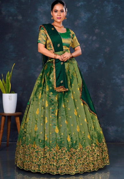 Woman wearing a green traditional outfit with gold embroidery