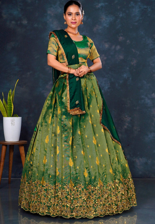 Woman wearing a green traditional outfit with gold embroidery