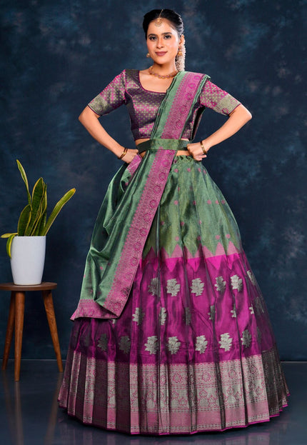 Woman wearing a traditional green and purple lehenga choli with dupatta