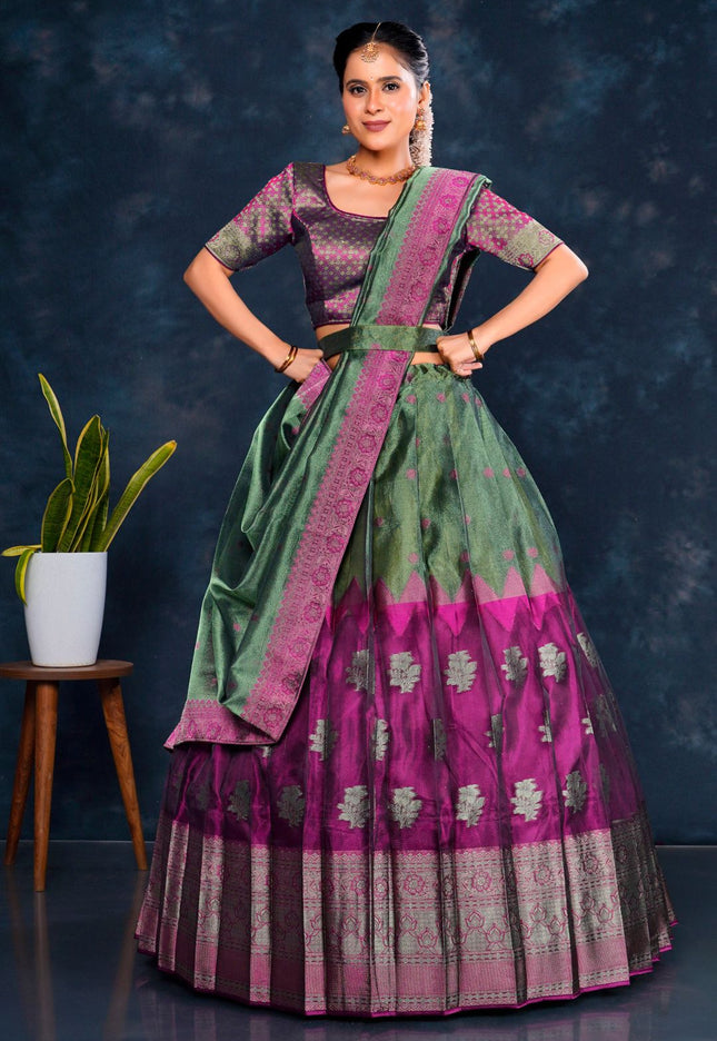 Woman wearing a traditional green and purple lehenga choli with dupatta