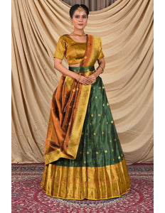 Woman wearing a traditional green and gold lehenga choli with dupatta