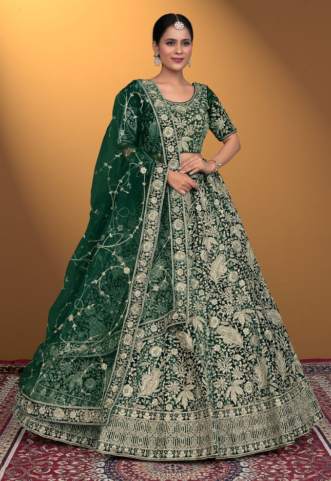 Woman wearing a green embroidered traditional outfit on a patterned rug with a yellow background