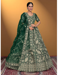 Woman wearing a green embroidered traditional outfit on a patterned rug with a yellow background