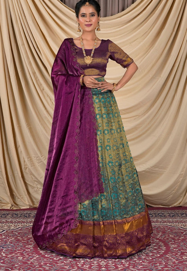 Woman wearing a traditional purple and green lehenga choli with dupatta