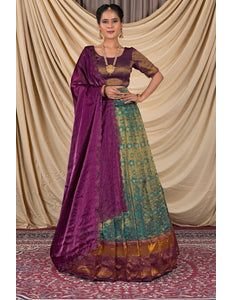 Woman wearing a traditional purple and green lehenga choli with dupatta