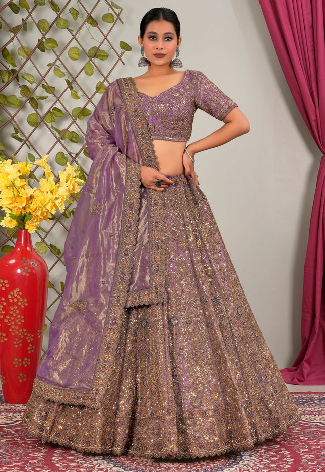 Woman wearing a traditional outfit with a purple lehenga choli with dupatta
