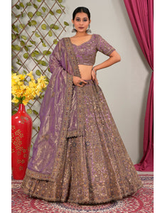 Woman wearing a traditional outfit with a purple lehenga choli with dupatta