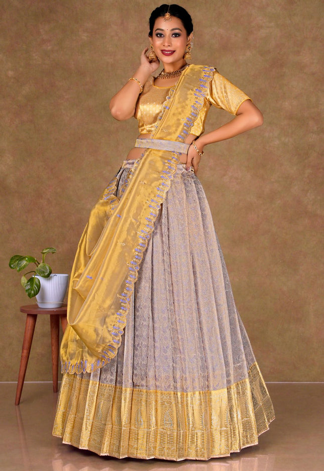 Woman wearing a yellow and lavender lehenga choli with dupatta