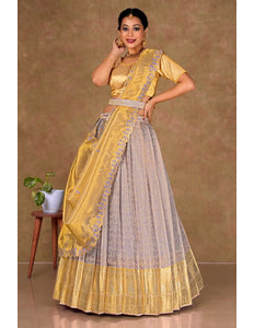 Woman wearing a yellow and lavender lehenga choli with dupatta