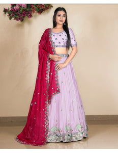 Woman wearing a pink and red traditional outfit with floral patterns
