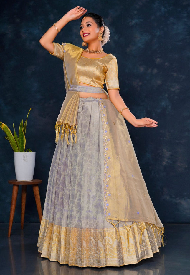 Woman in a traditional gold and lavender lehenga choli with dupatta