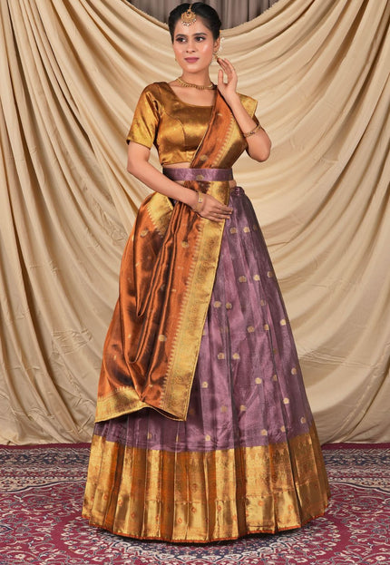 Woman wearing a traditional gold and purple lehenga choli with dupatta