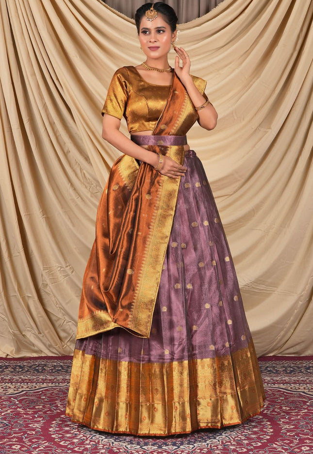 Woman wearing a traditional gold and purple lehenga choli with dupatta