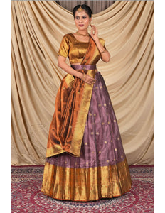 Woman wearing a traditional gold and purple lehenga choli with dupatta