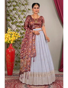 Woman in traditional outfit with a maroon and lavender lehenga choli