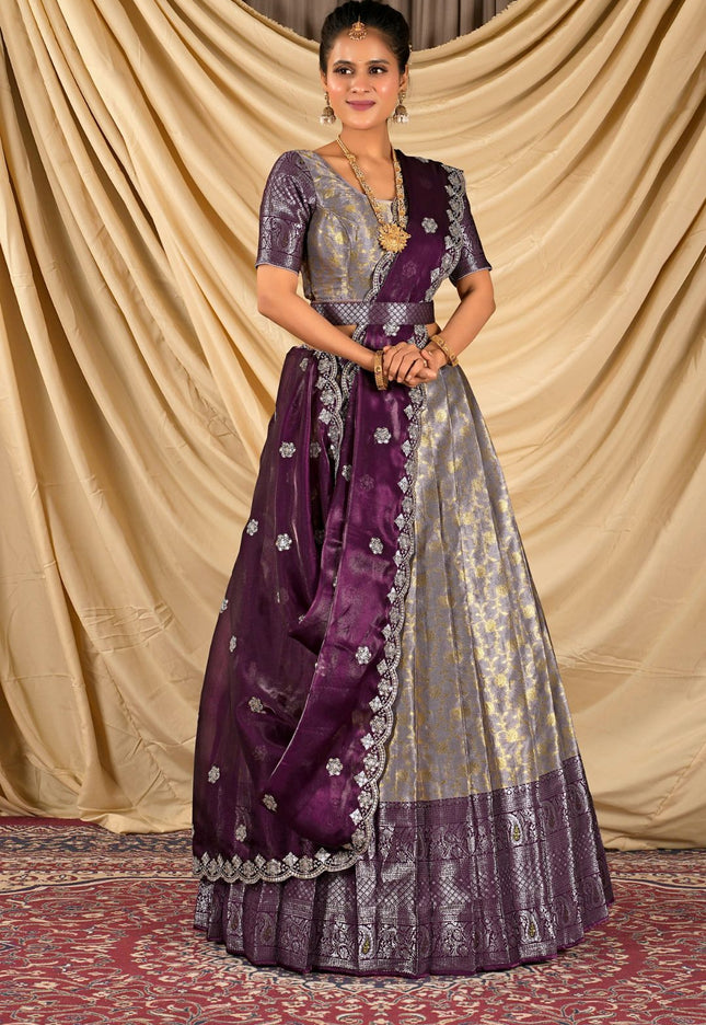 Woman wearing a traditional purple and silver lehenga choli with dupatta