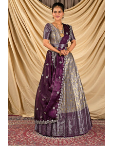 Woman wearing a traditional purple and silver lehenga choli with dupatta