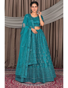 Woman wearing a teal embroidered traditional outfit with a matching dupatta