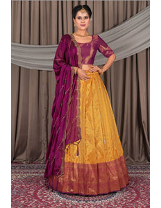 Woman wearing a traditional yellow and purple saree with a matching blouse