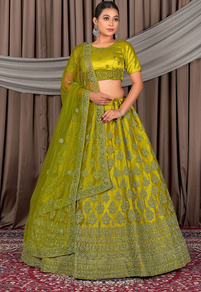 Woman wearing a green embroidered traditional outfit with a matching dupatta