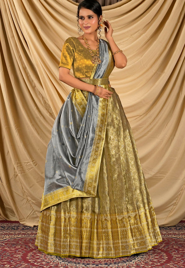 Woman wearing a yellow and gray lehenga choli with dupatta