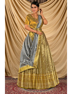 Woman wearing a yellow and gray lehenga choli with dupatta