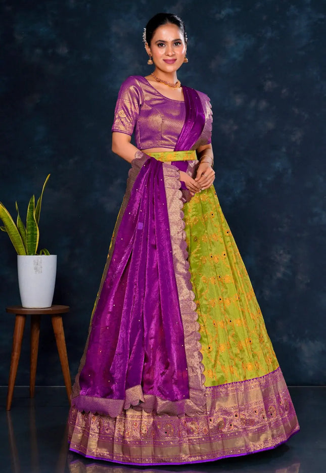 Woman wearing a purple and green lehenga choli with dupatta