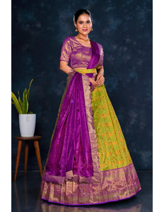 Woman wearing a purple and green lehenga choli with dupatta
