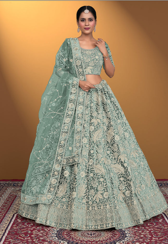 Woman wearing a light green embroidered traditional outfit on a patterned