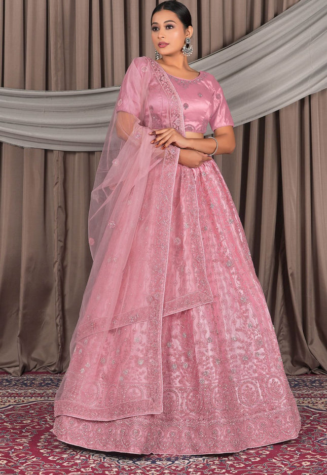 Woman wearing a pink traditional outfit with a lehenga choli