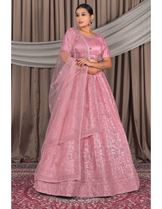 Woman wearing a pink traditional outfit with a lehenga choli