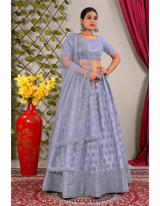 Woman in a light blue traditional outfit standing