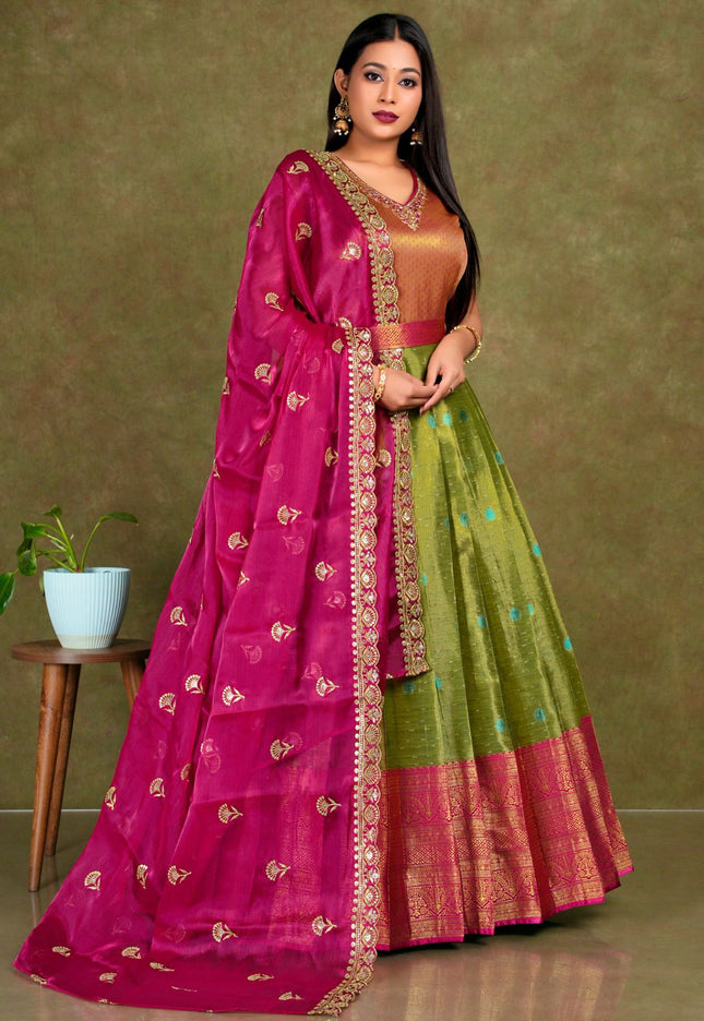 Woman wearing a traditional pink and green gown with dupatta