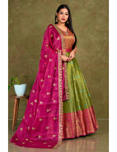 Woman wearing a traditional pink and green gown with dupatta