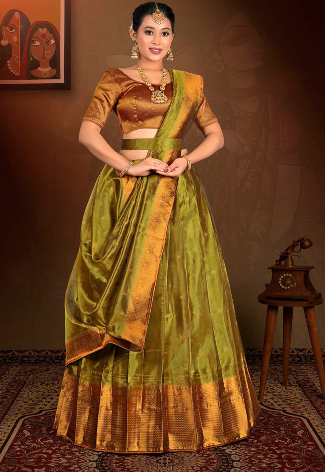 Woman wearing a traditional green and gold lehenga with a matching blouse