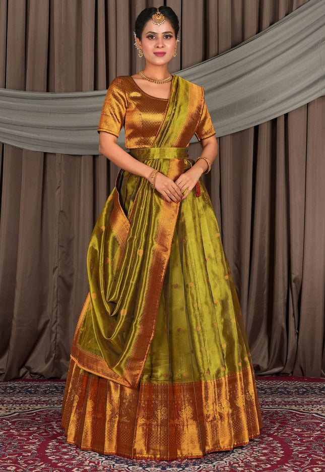 Woman wearing a traditional green and gold lehenga with a matching blouse