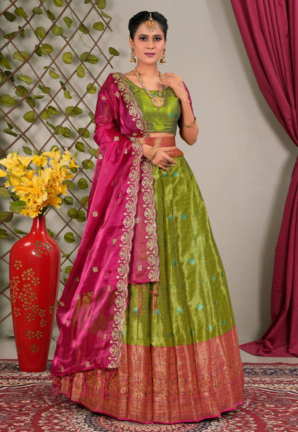 Woman wearing a green and pink traditional lehenga choli with dupatta