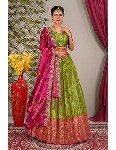 Woman wearing a green and pink traditional lehenga choli with dupatta