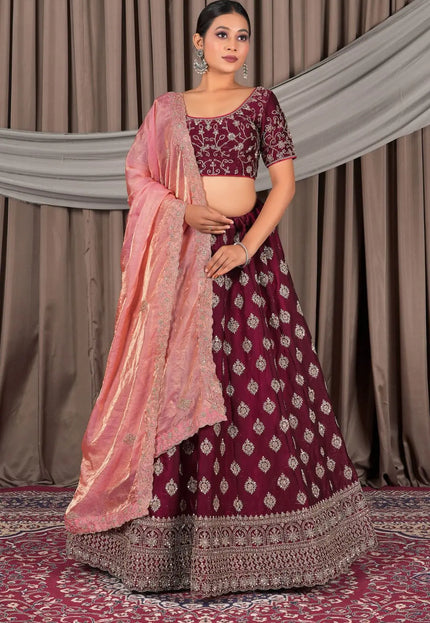 Woman wearing a maroon and pink traditional lehenga choli with dupatta