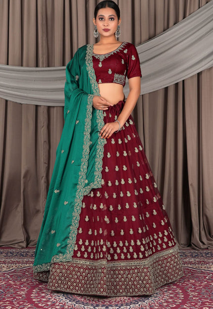Woman wearing a maroon traditional outfit with a green dupatta