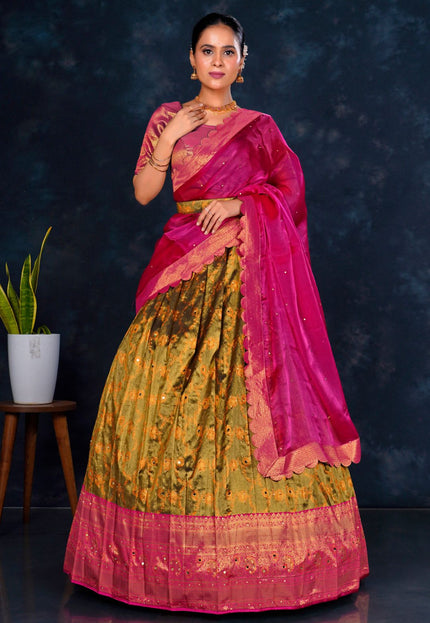 Woman wearing a traditional outfit with a pink and green lehenga choli with dupatta