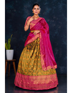 Woman wearing a traditional outfit with a pink and green lehenga choli with dupatta