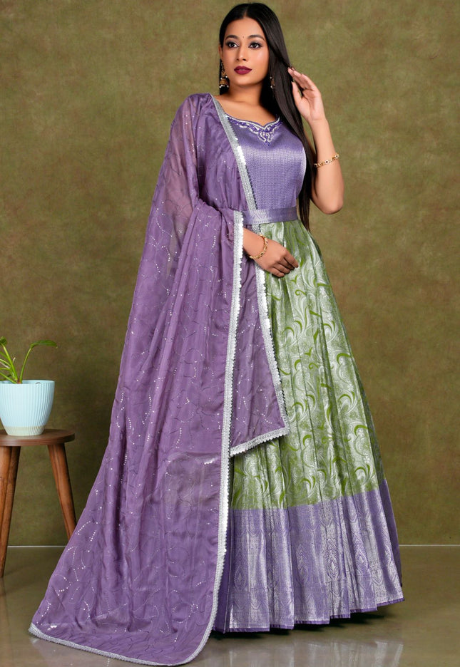Woman wearing a purple and green traditional outfit with a matching dupatta