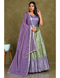 Woman wearing a purple and green traditional outfit with a matching dupatta