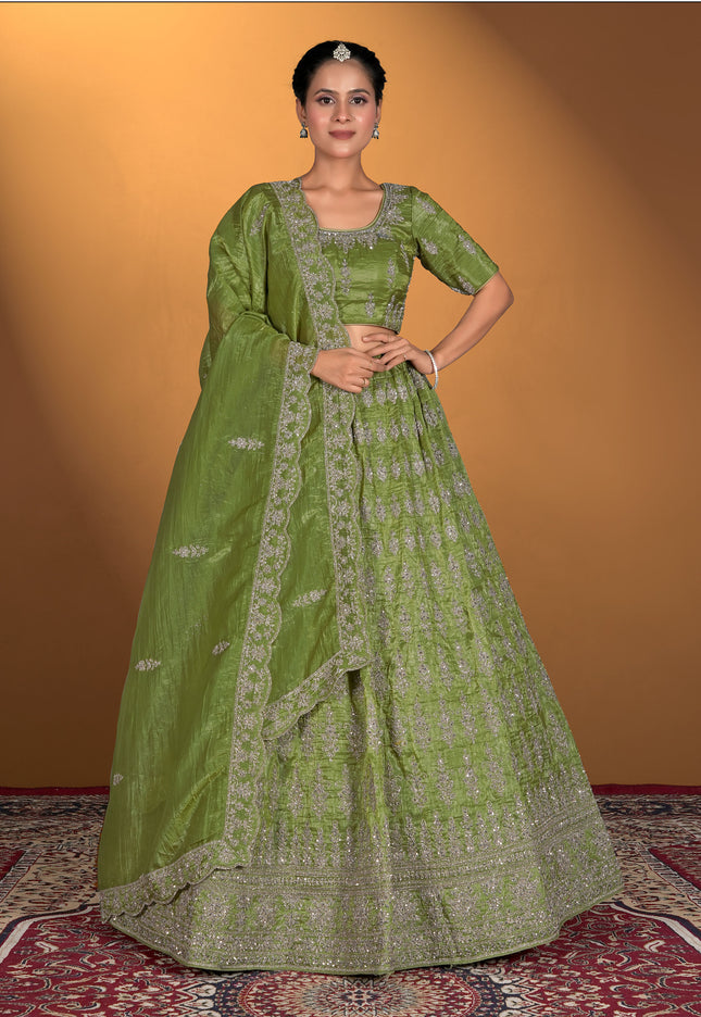 Woman wearing a green traditional outfit with intricate patterns