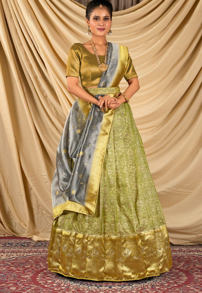 Woman wearing a green and gold traditional lehenga choli with dupatta