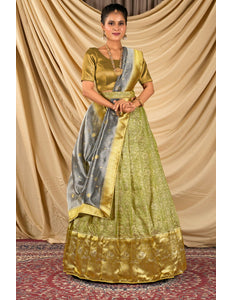 Woman wearing a green and gold traditional lehenga choli with dupatta