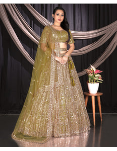 Woman in a traditional green and gold lehenga outfit