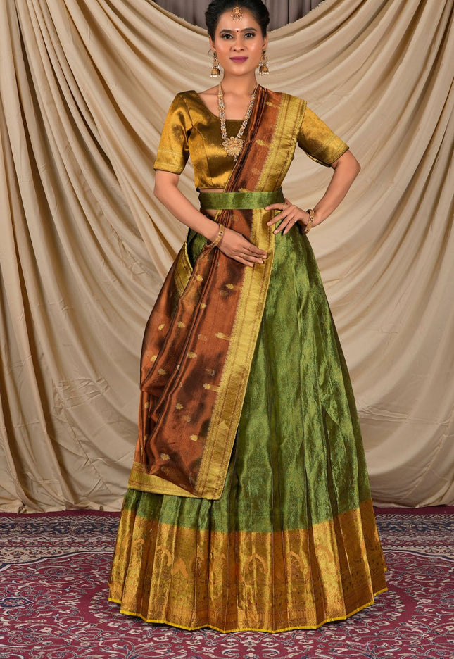 Woman wearing a traditional green and gold saree with a matching blouse
