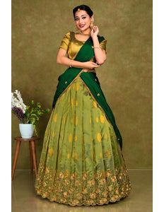 Woman wearing a green and gold traditional outfit